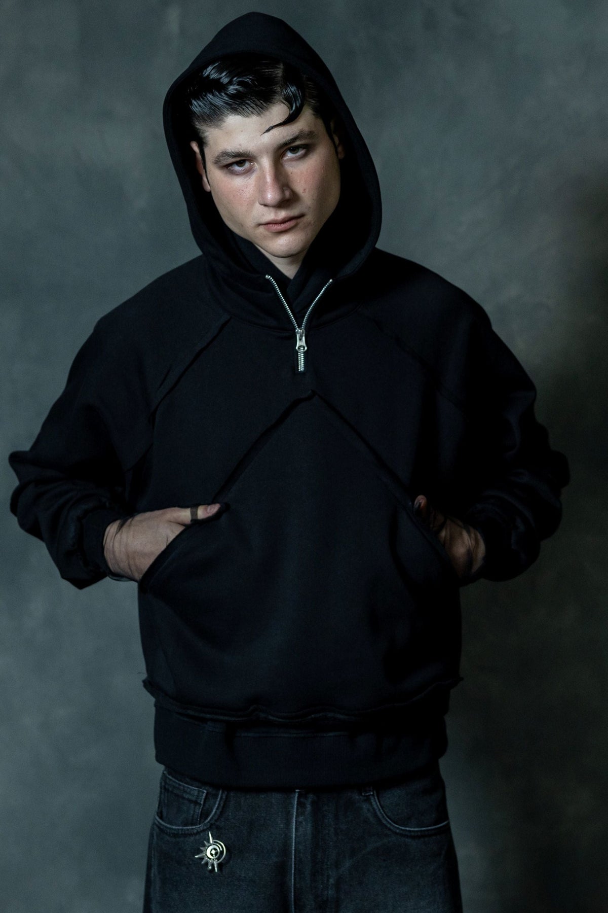 Men wearing premium black zip neck hoodie with hood up in minimal modern streetwear style