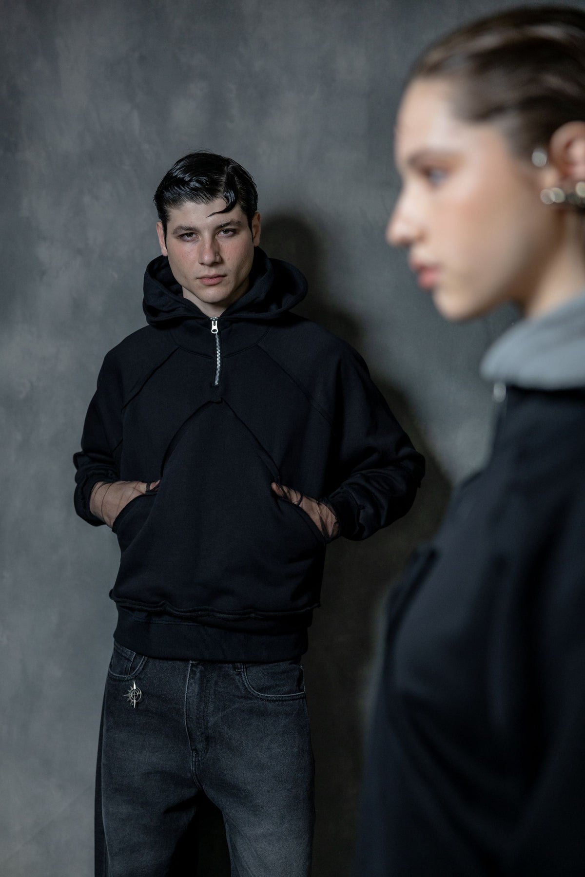 Couple wearing premium black zip neck hoodies styled in a modern urban streetwear look, high-quality lifestyle portrait composition
