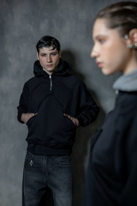 Couple wearing premium black zip neck hoodies styled in a modern urban streetwear look, high-quality lifestyle portrait composition