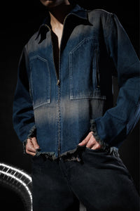 Close up of a blue denim jacket with zipper closure and frayed edges, highlighting modern streetwear design