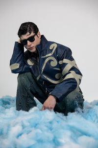 Men's blue embossed leather jacket with beige appliqué styled for modern streetwear