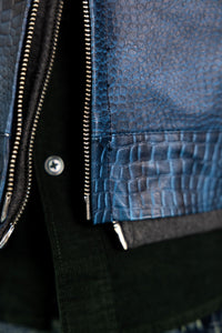Close-up detail of heavy-duty metal zipper on a premium blue embossed leather jacket