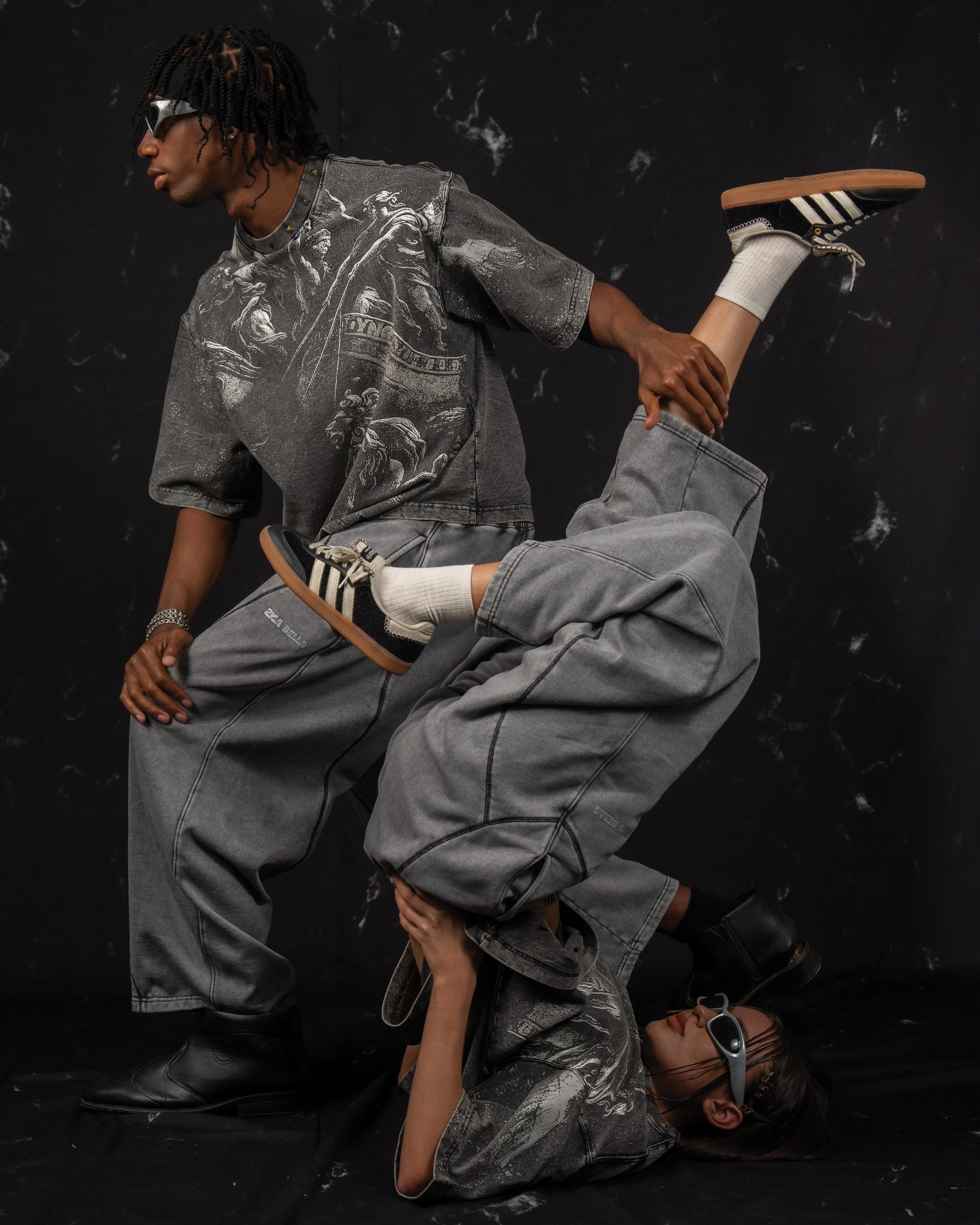 High-concept artistic fashion campaign image featuring an oversized washed charcoal graphic t-shirt