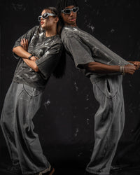 Editorial lifestyle pose featuring an oversized charcoal graphic t-shirt with clean aesthetics