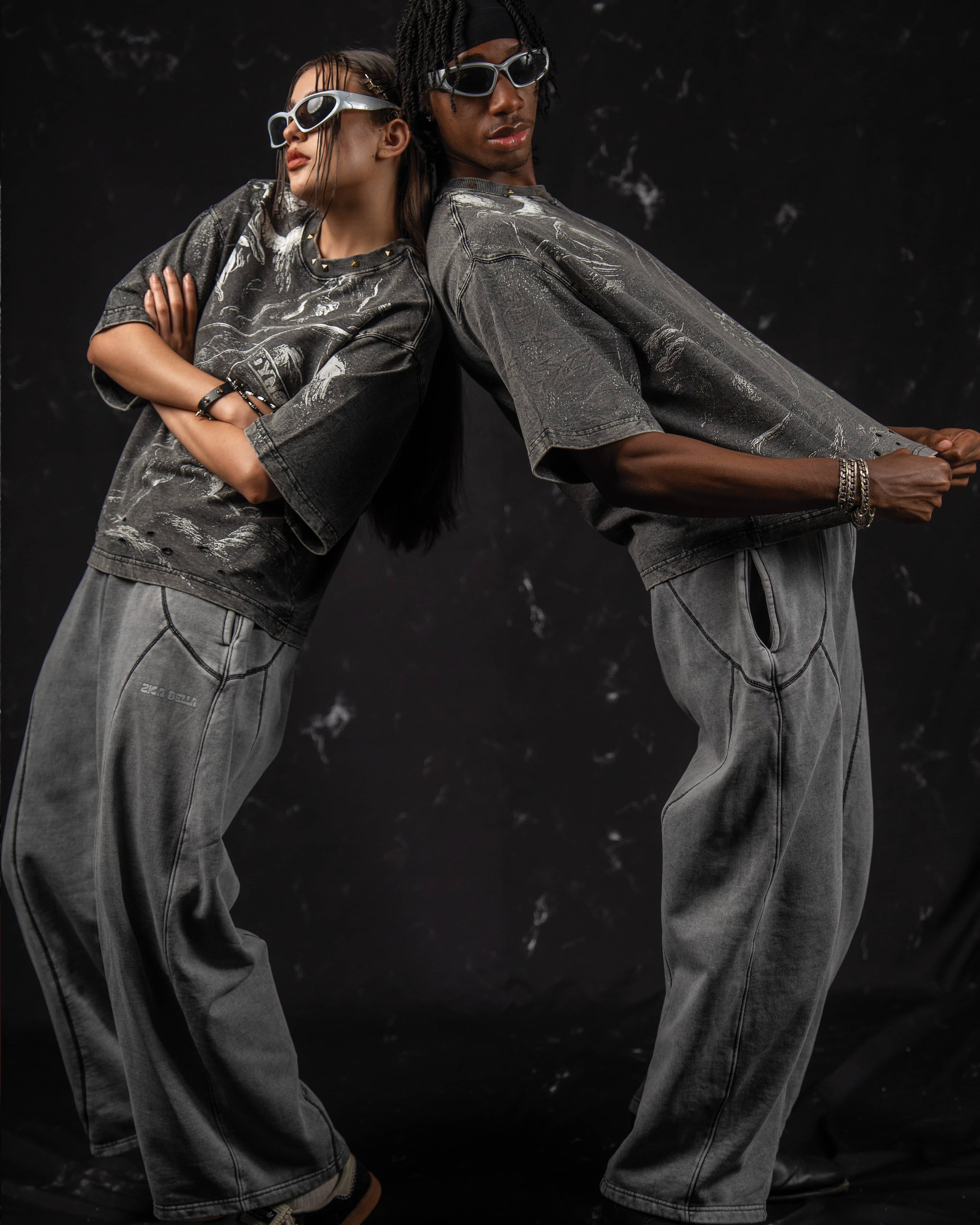 Editorial lifestyle pose featuring an oversized charcoal graphic t-shirt with clean aesthetics