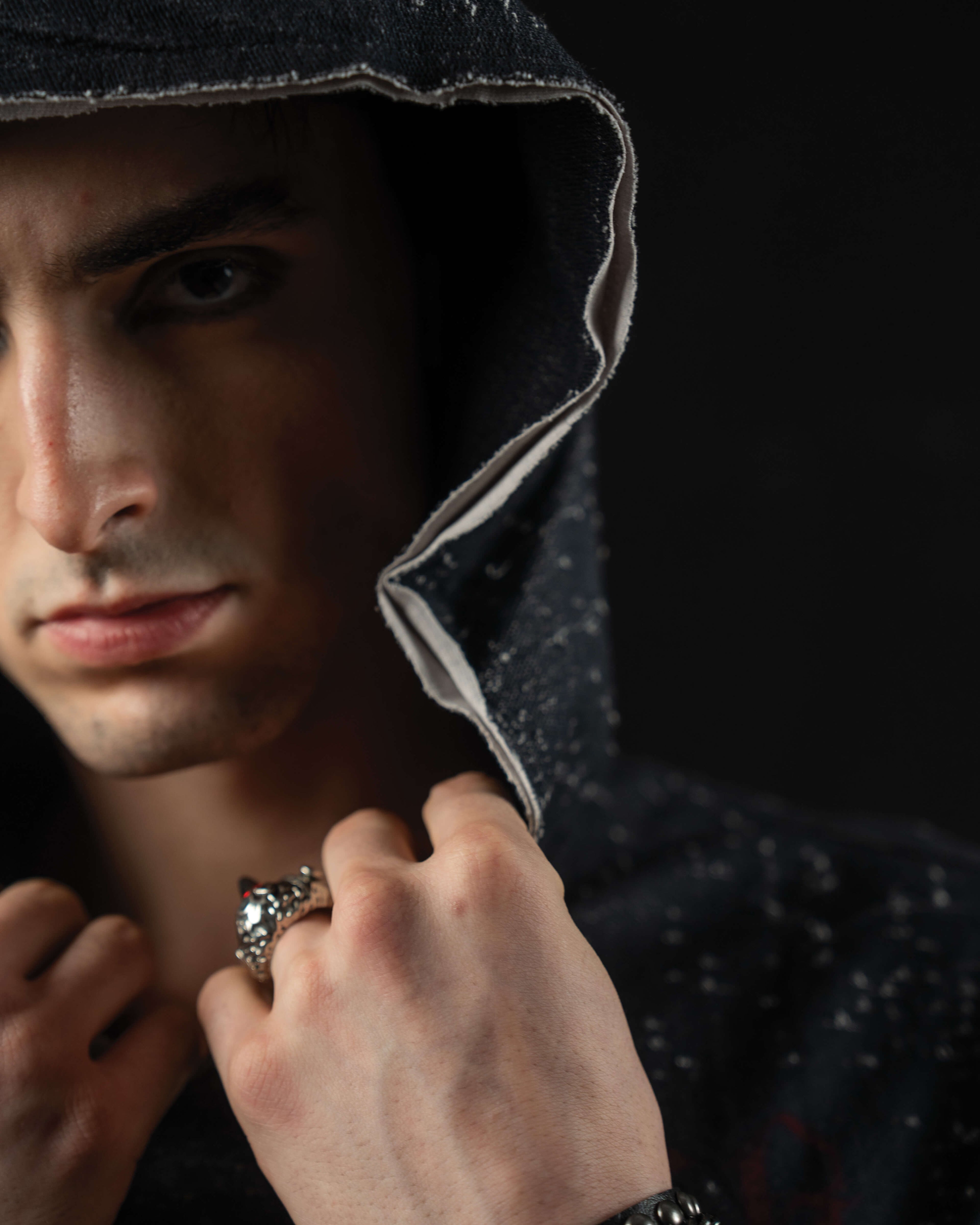 Close-up of the hood construction and distressed neckline on a washed charcoal oversized tee
