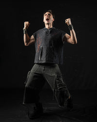 Editorial fashion shot of a model styling a washed charcoal oversized hooded graphic tee in a studio