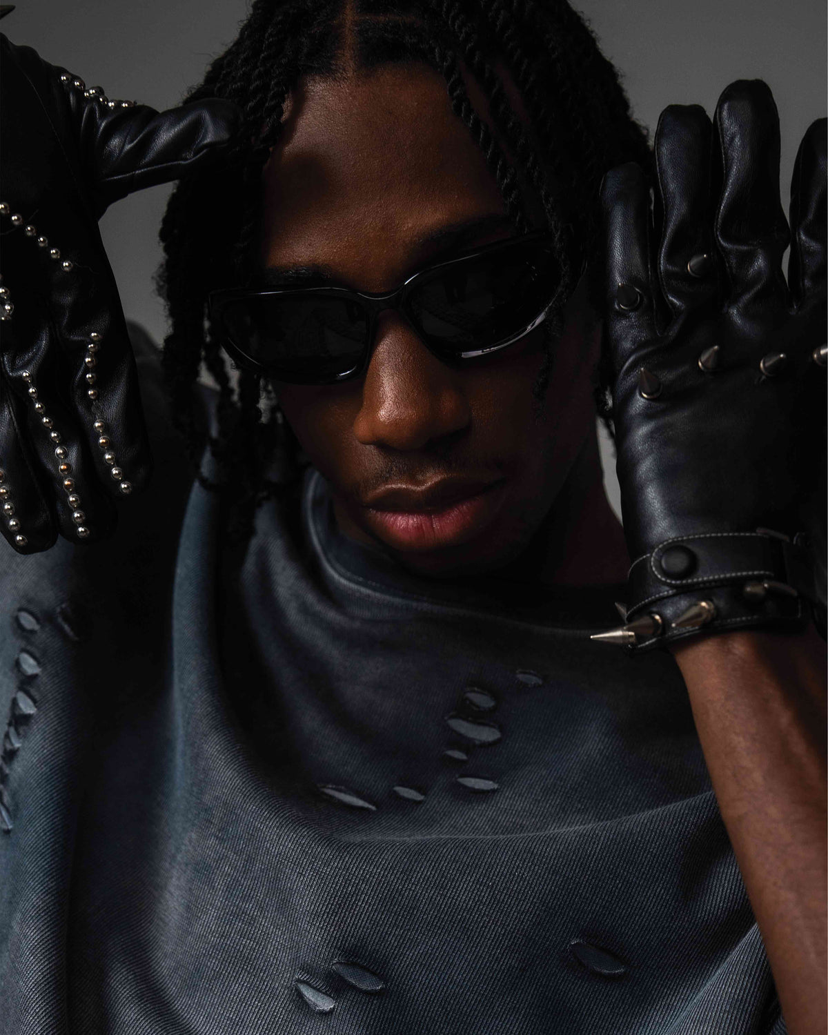 Close up of DRYXEN distressed oversized black t-shirt styled with black gloves