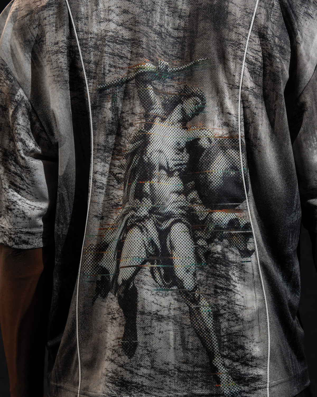 Extreme close-up of the back artwork detail printed on a grey and black oversized jersey