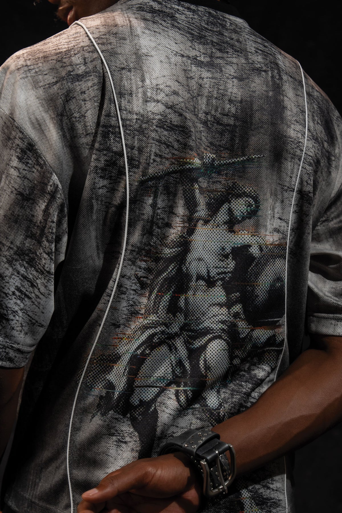 Close up back view showing the large graphic artwork printed on a grey and black oversized jersey