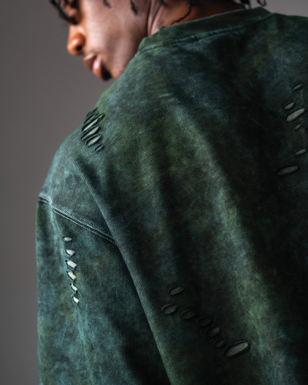 Closeup detail of distressed fabric on GRN_ERR acid wash green streetwear tee