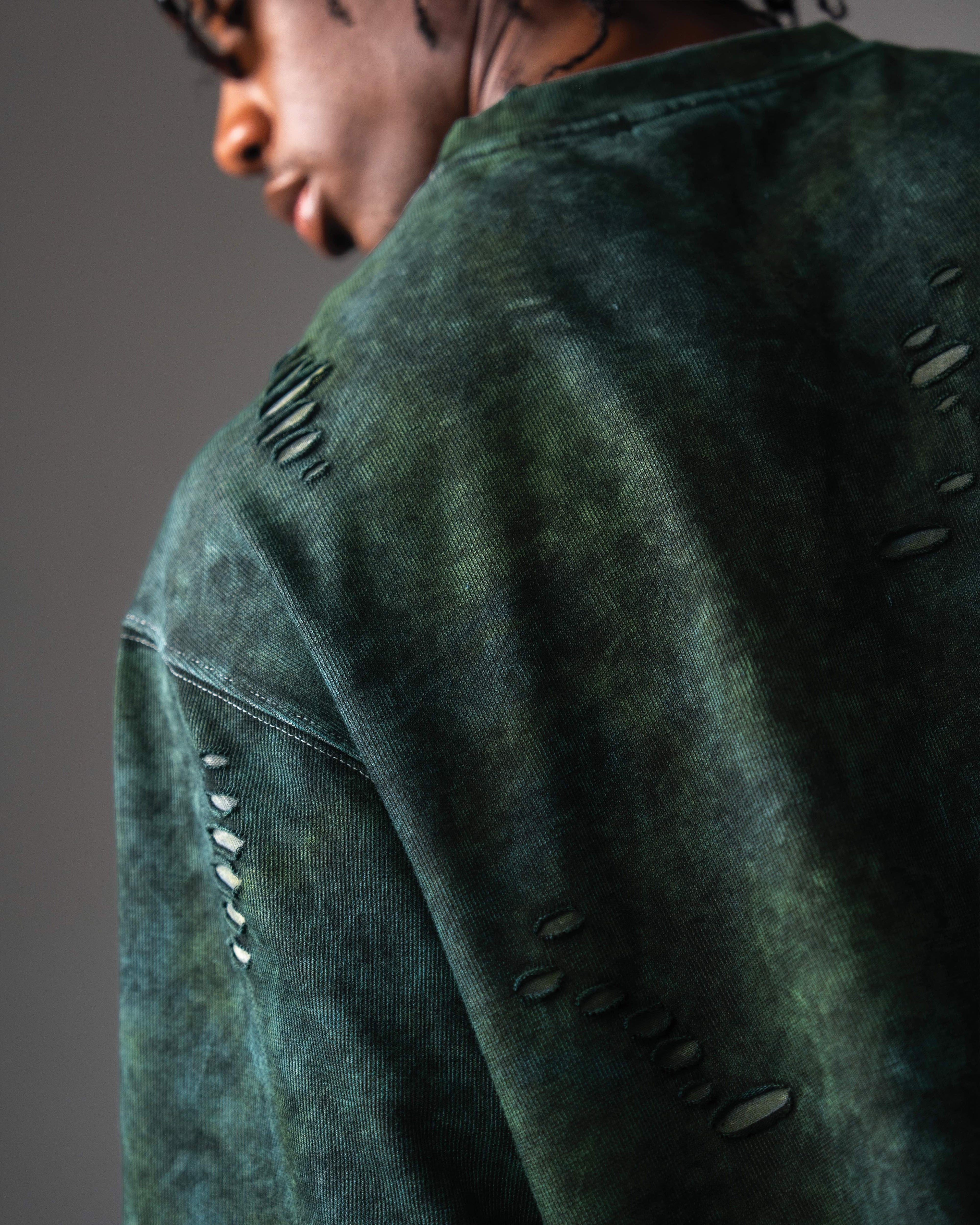 Closeup detail of distressed fabric on GRN_ERR acid wash green streetwear tee