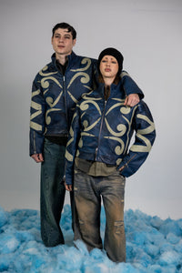 Couple wearing matching blue embossed leather jackets with beige appliqué