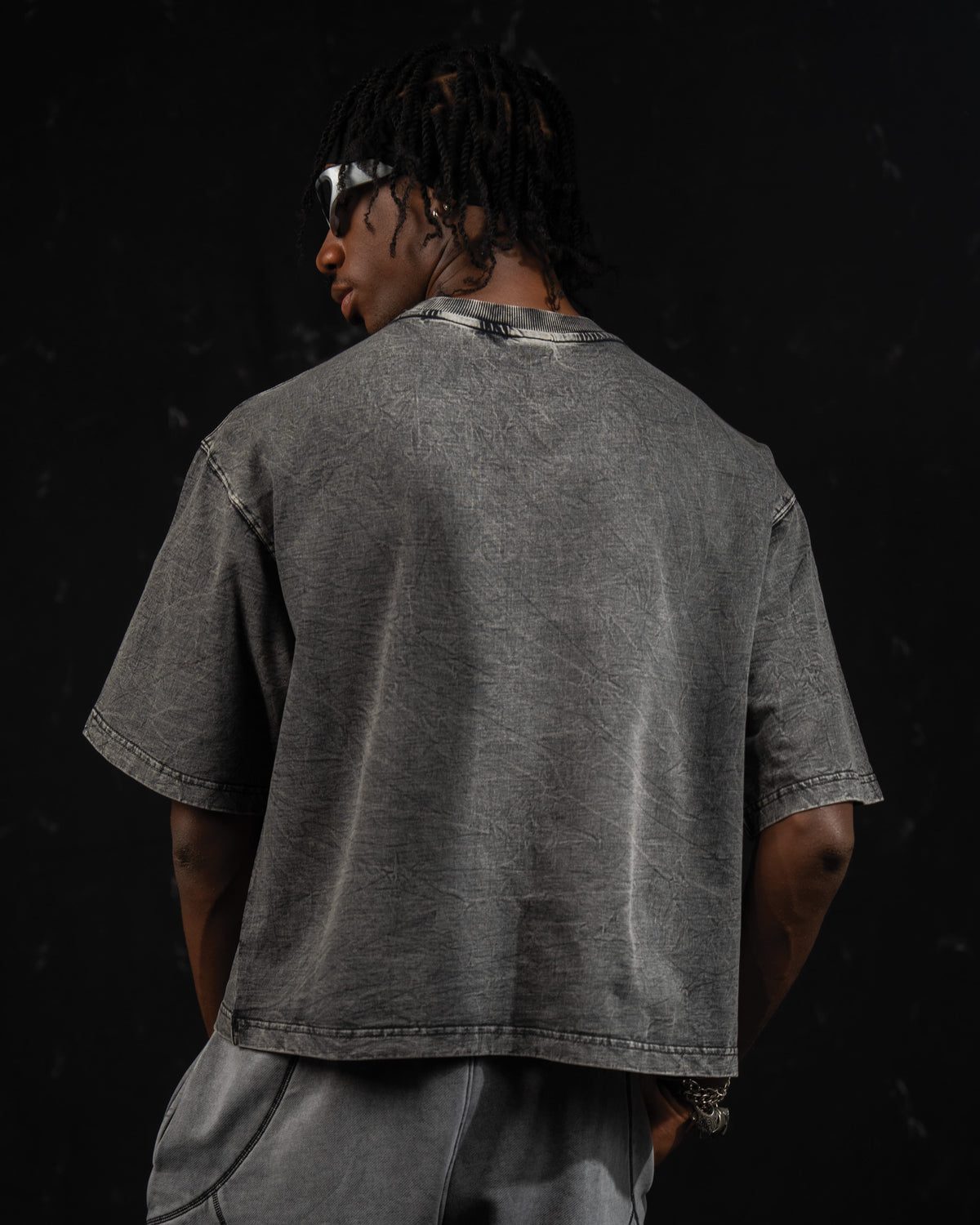 Studio back view of a washed charcoal oversized t-shirt highlighting the drop-shoulder fit