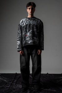 Front full-length studio portrait of a model wearing the washed charcoal SPYCRA.NODE screenprinted long sleeve tee