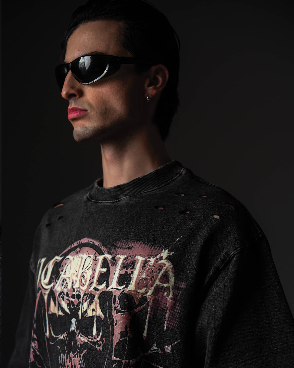 ide portrait of a man wearing a black skull graphic t-shirt with distressed shoulder details