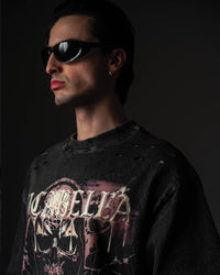 ide portrait of a man wearing a black skull graphic t-shirt with distressed shoulder details