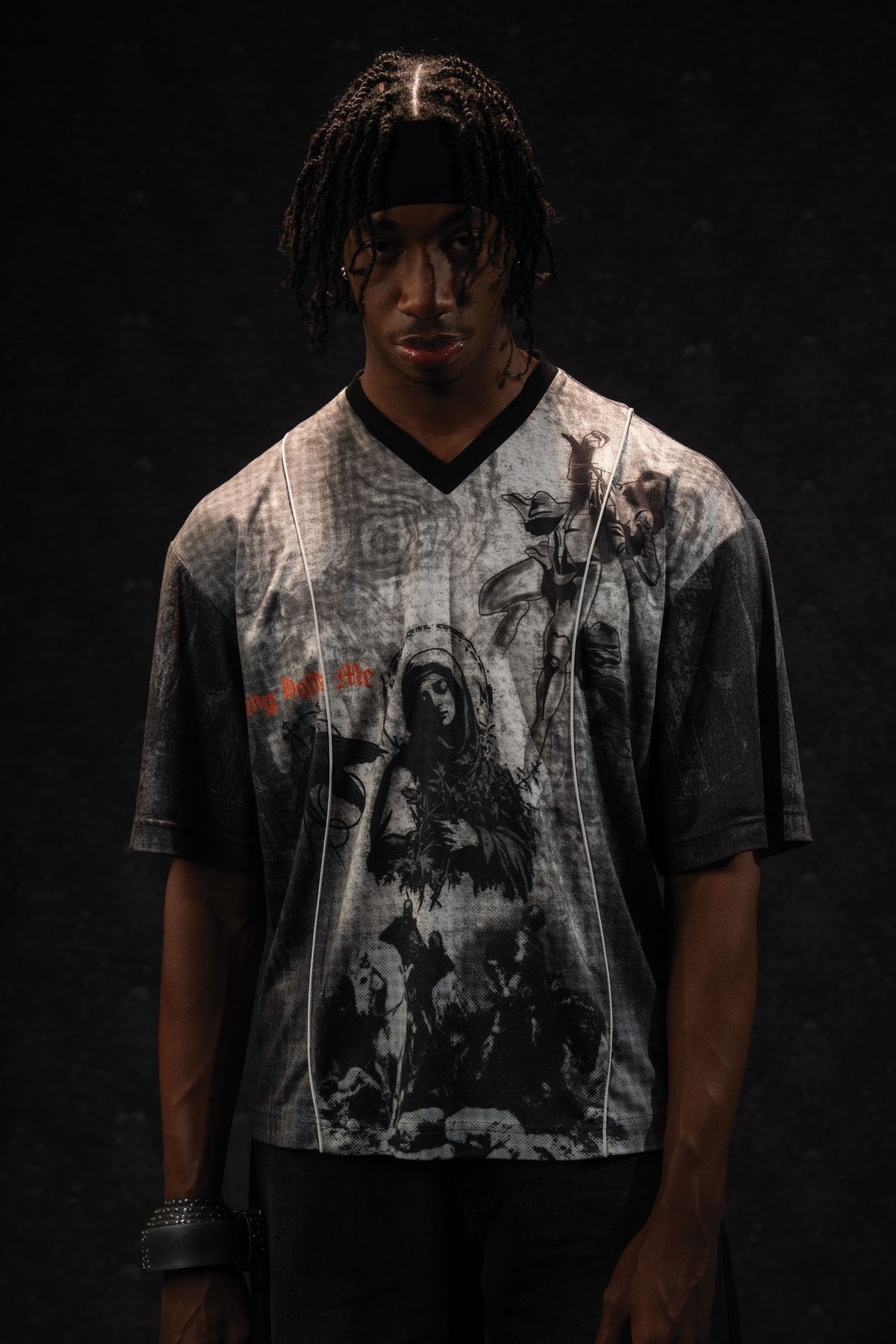 Studio portrait of a man modeling a grey and black oversized graphic jersey