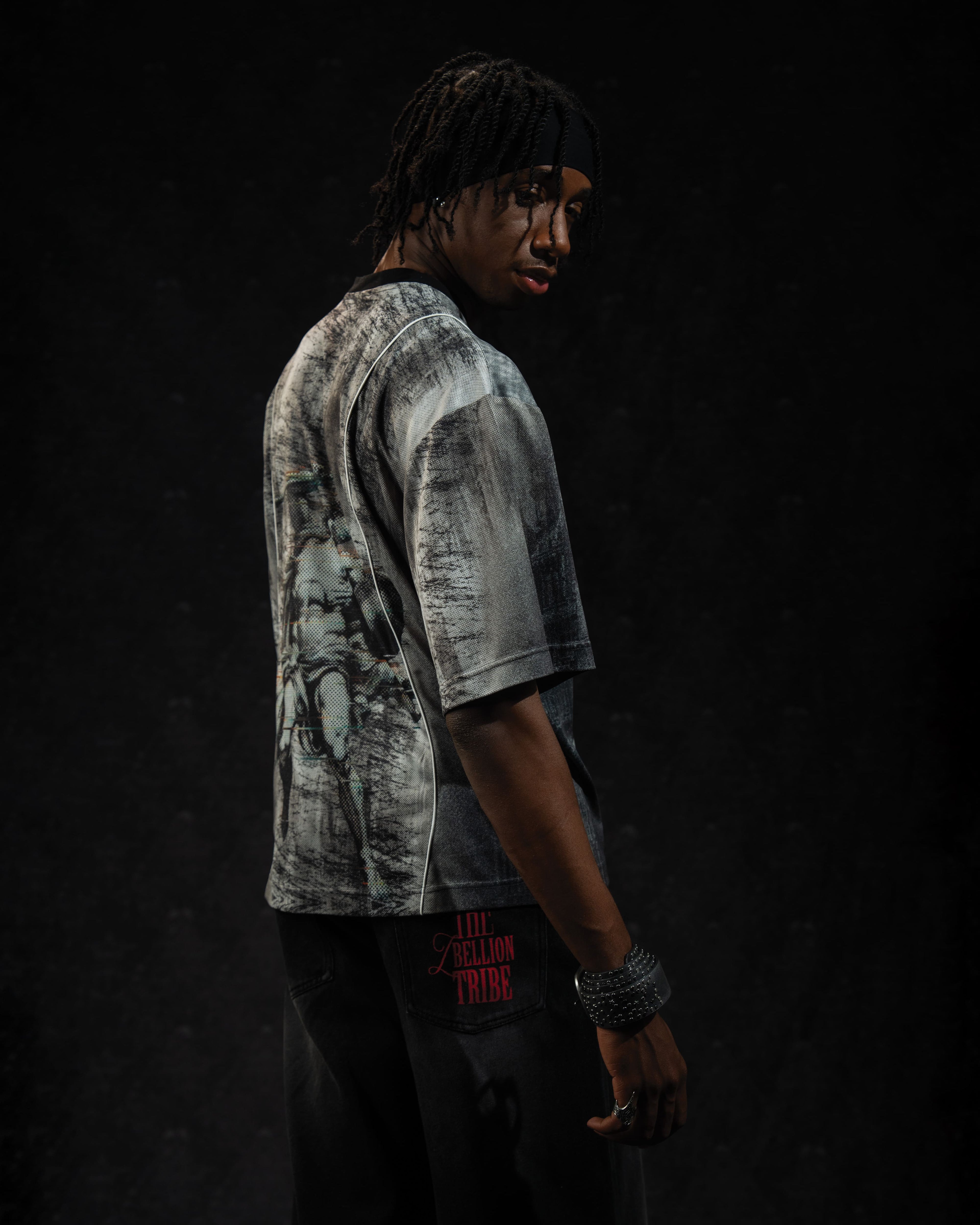 Side profile view of a man wearing a relaxed-fit grey and black oversized streetwear jersey