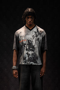 Front full-length shot of a man wearing a grey and black premium oversized graphic V-neck jersey