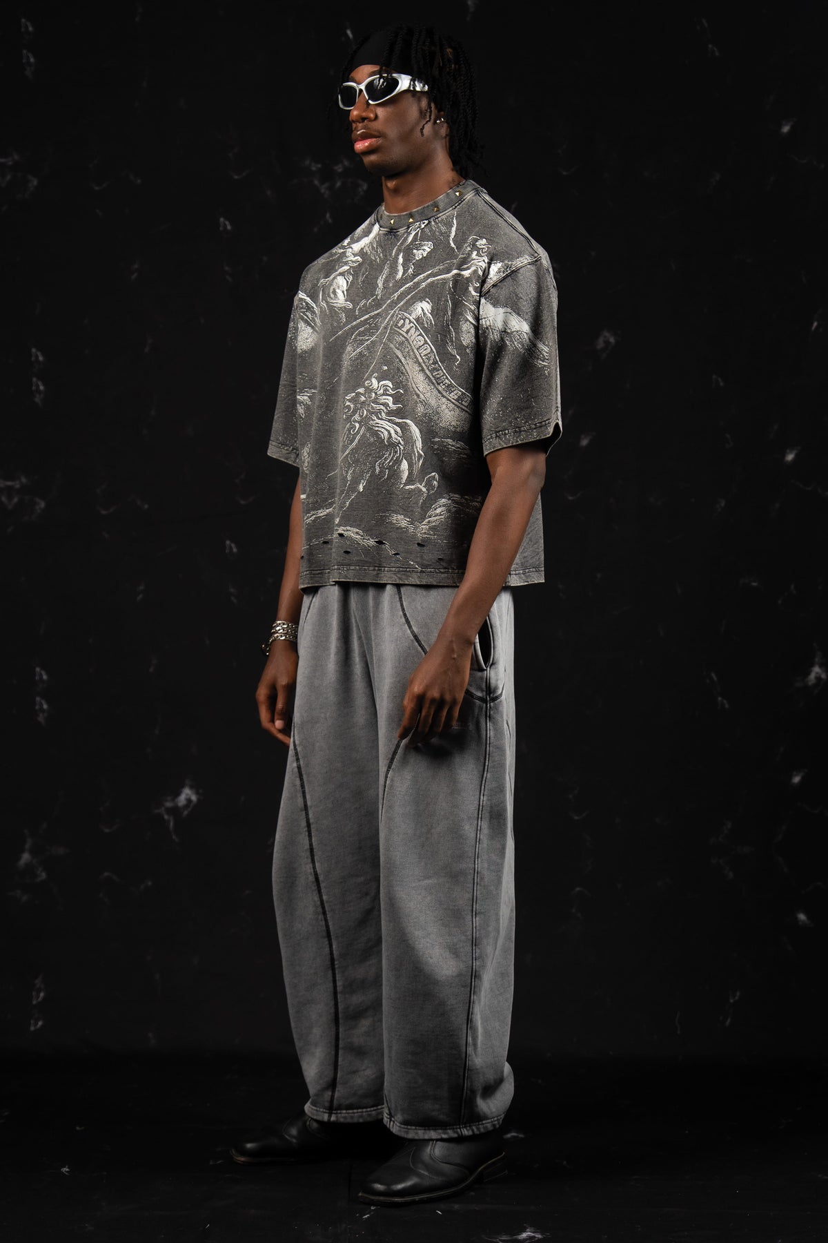 Side profile view of a man showing the relaxed fit of a washed charcoal oversized graphic t-shirt