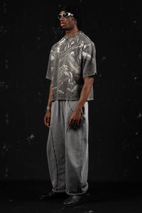 Side profile view of a man showing the relaxed fit of a washed charcoal oversized graphic t-shirt
