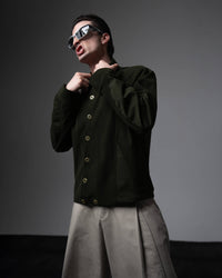 Side profile portrait of a man wearing a dark olive textured oversized shirt