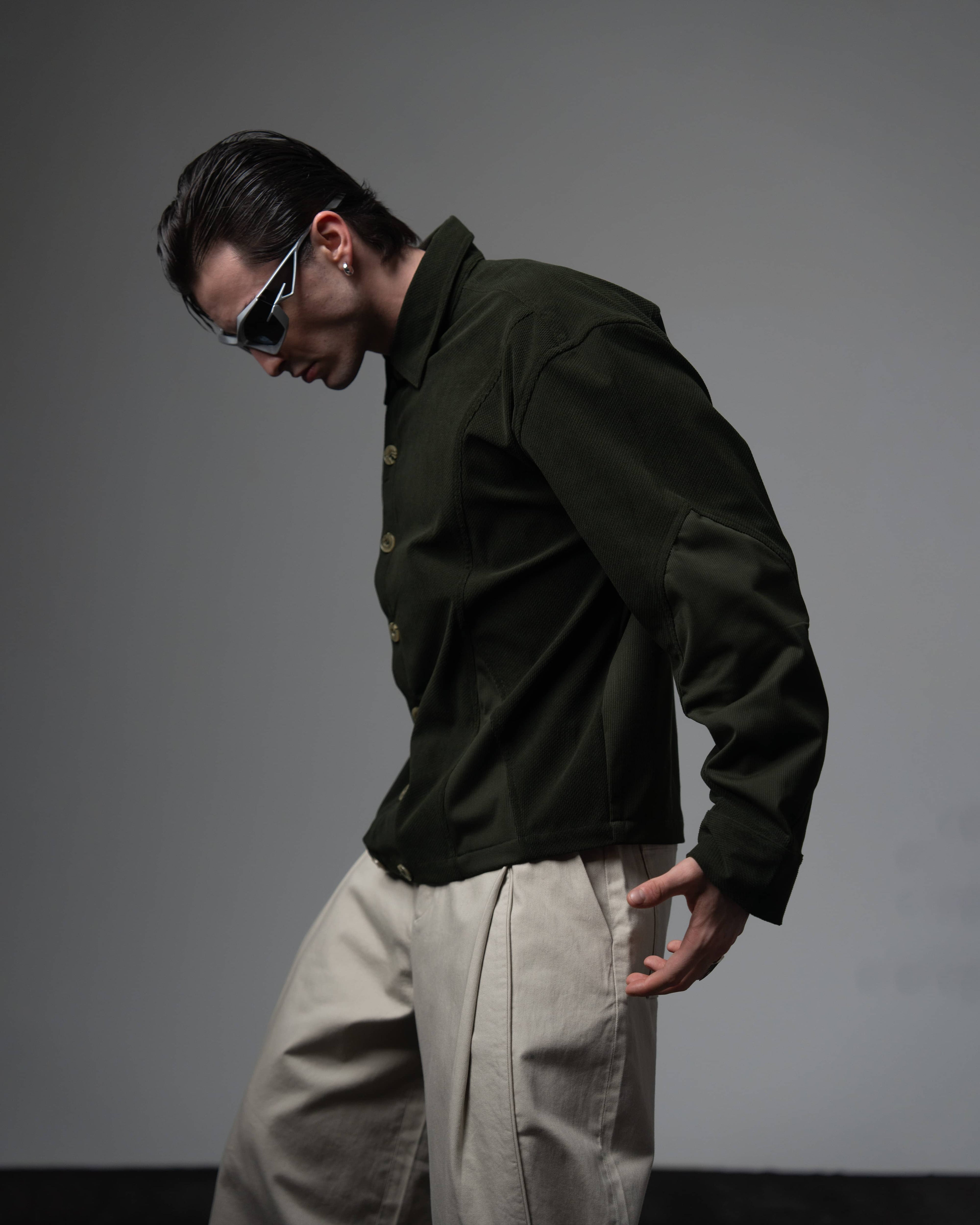 Right-side profile view of a man modeling a textured oversized dark olive shirt