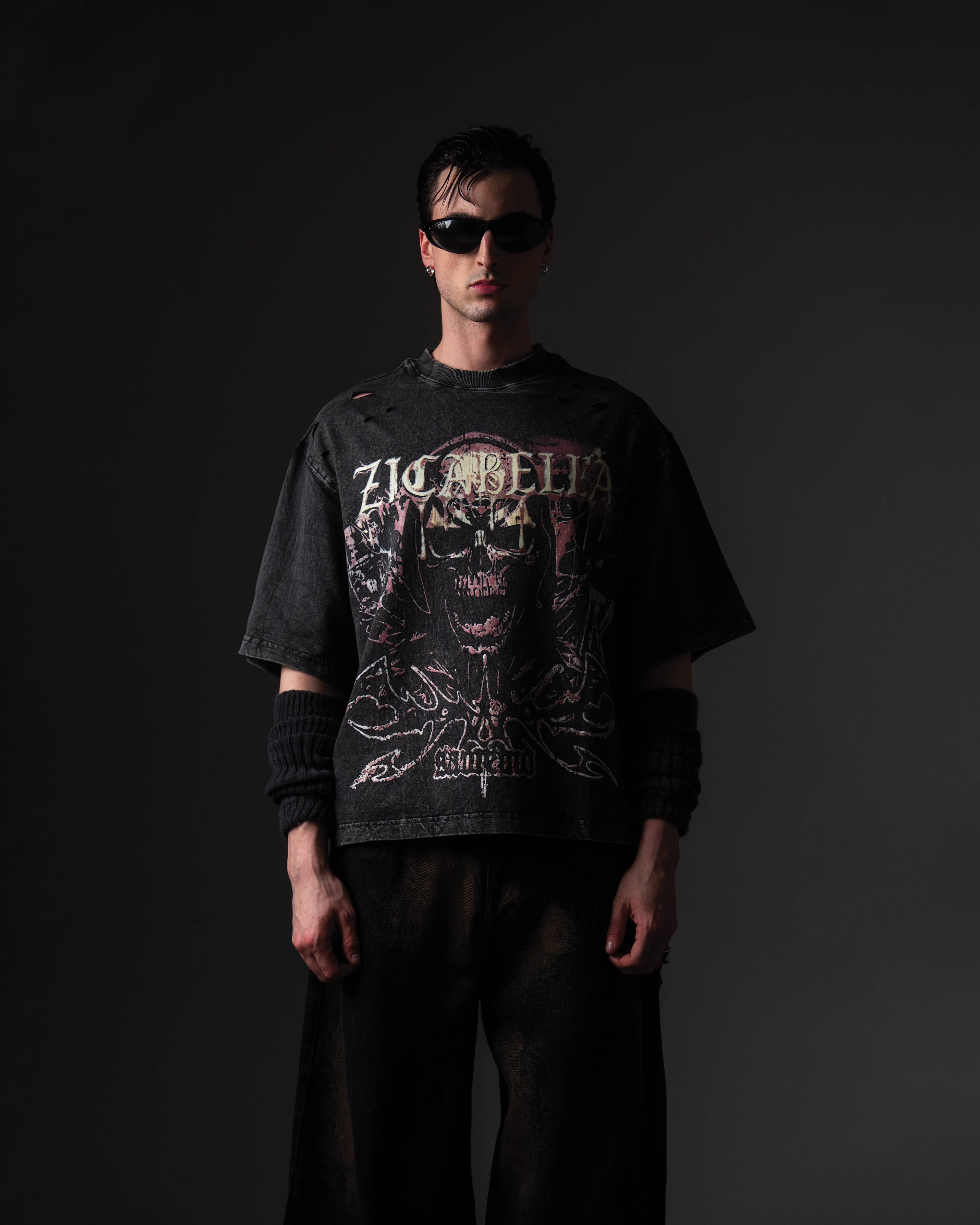 Clean studio front shot of a man wearing an oversized black skull graphic t-shirt in a relaxed fit