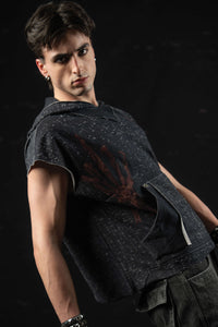Angled portrait of a model styling a washed charcoal sleeveless hooded graphic tee