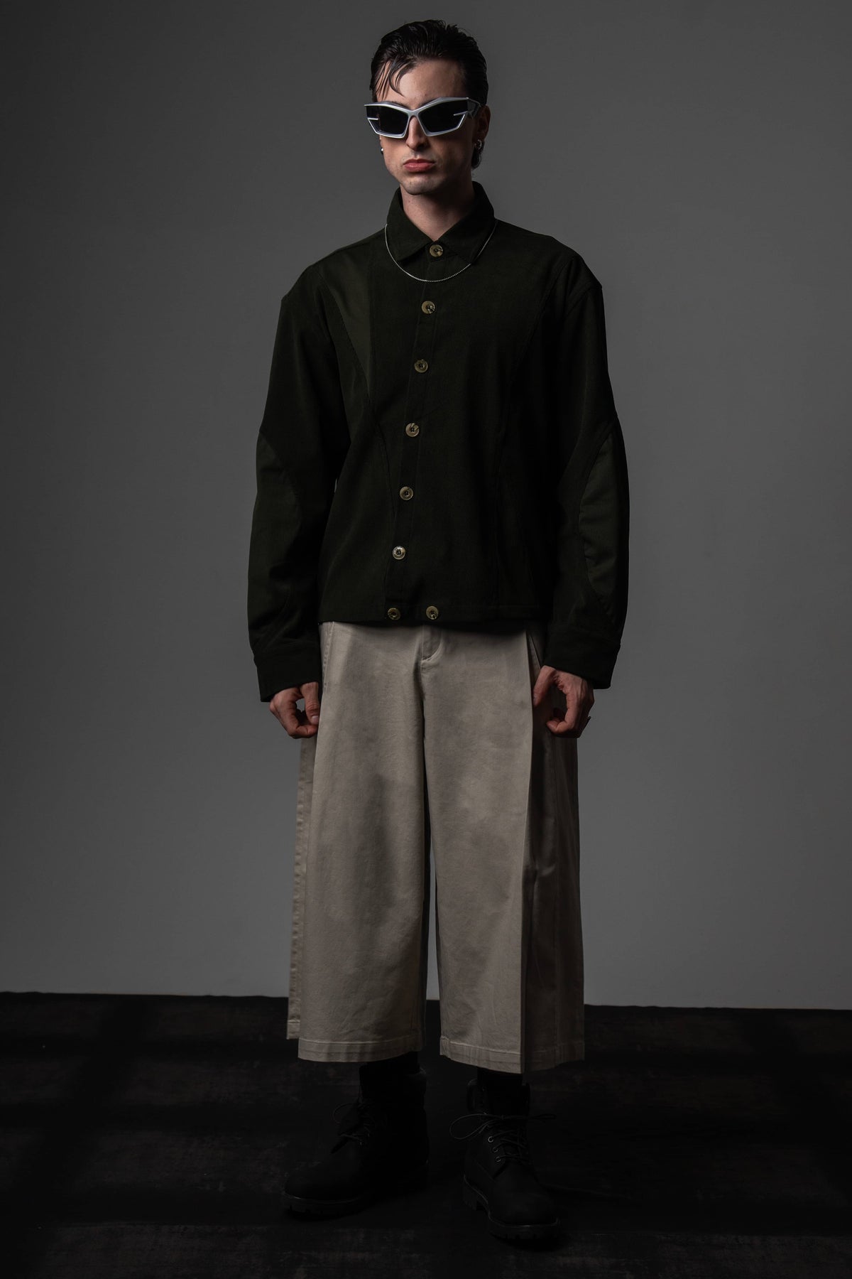 Full-length high-fashion portrait of a man styling a premium heavyweight dark olive textured shirt