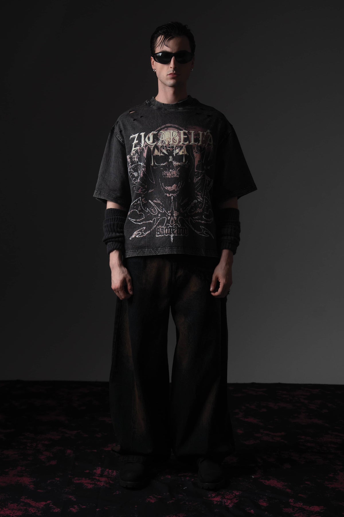 Front full-length shot of a man wearing a washed black oversized skull graphic t-shirt by Zicabella