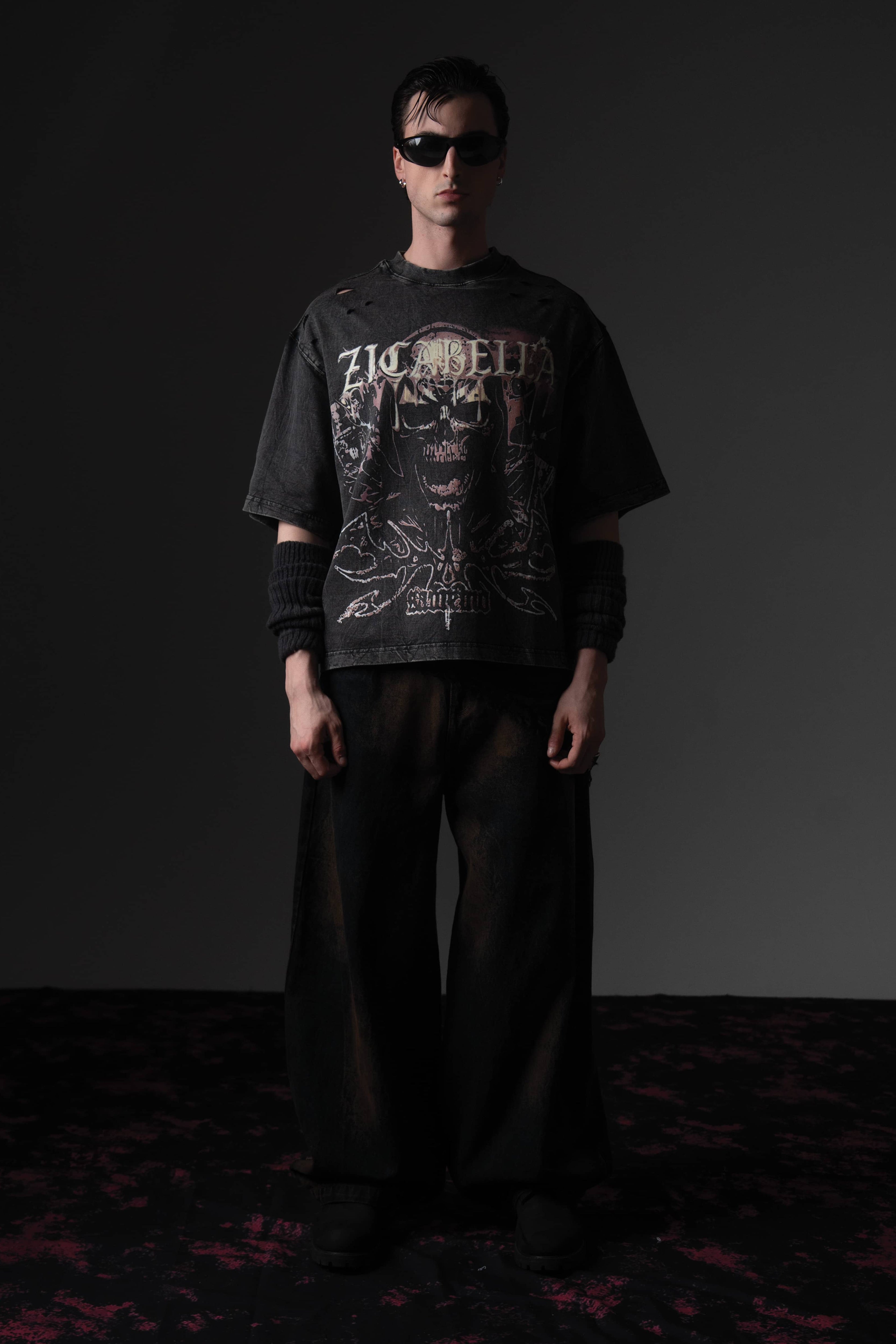 Front full-length shot of a man wearing a washed black oversized skull graphic t-shirt by Zicabella