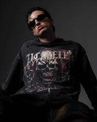 Low-angle studio shot of a man wearing a relaxed oversized washed black t-shirt with a large skull print