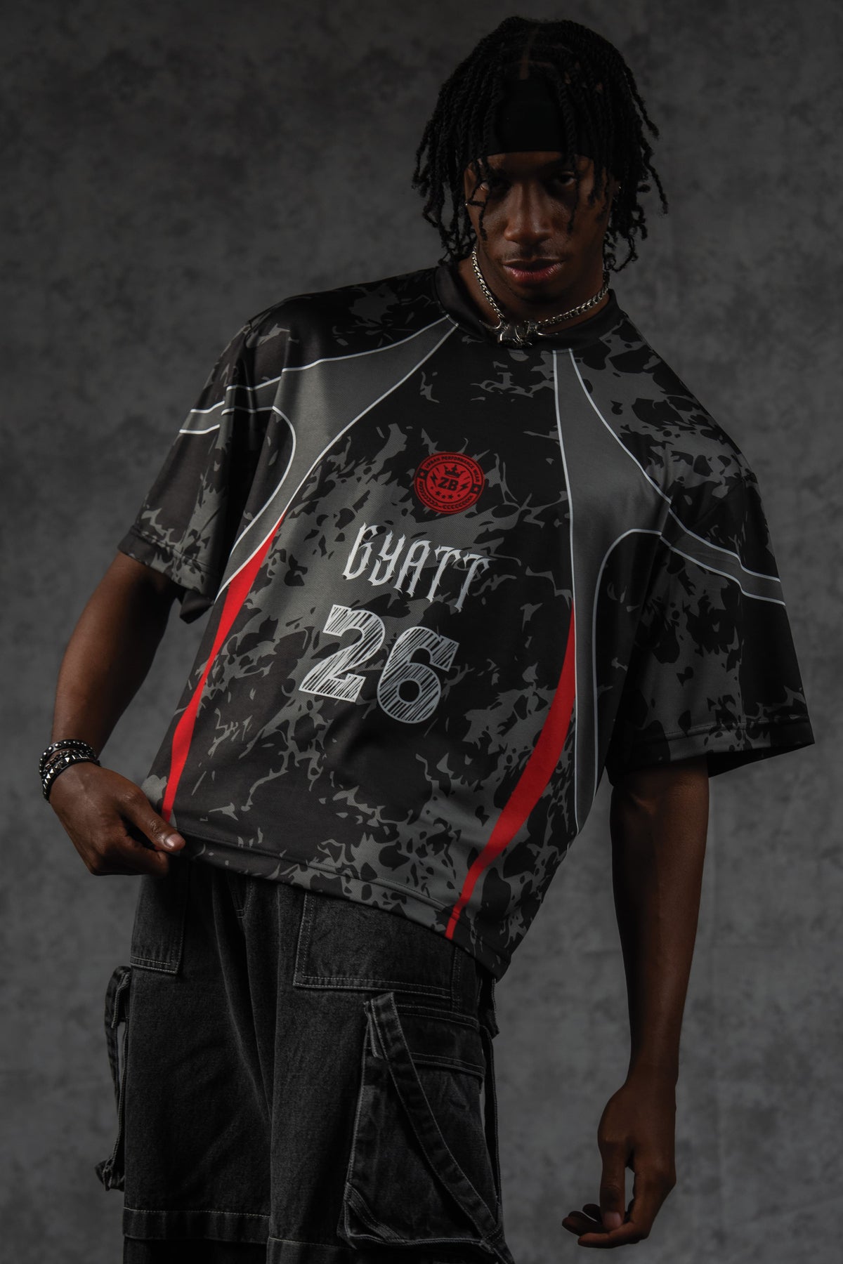 Front portrait of a man showcasing the ZBRIX_26 oversized jersey with custom grey panels and red accents
