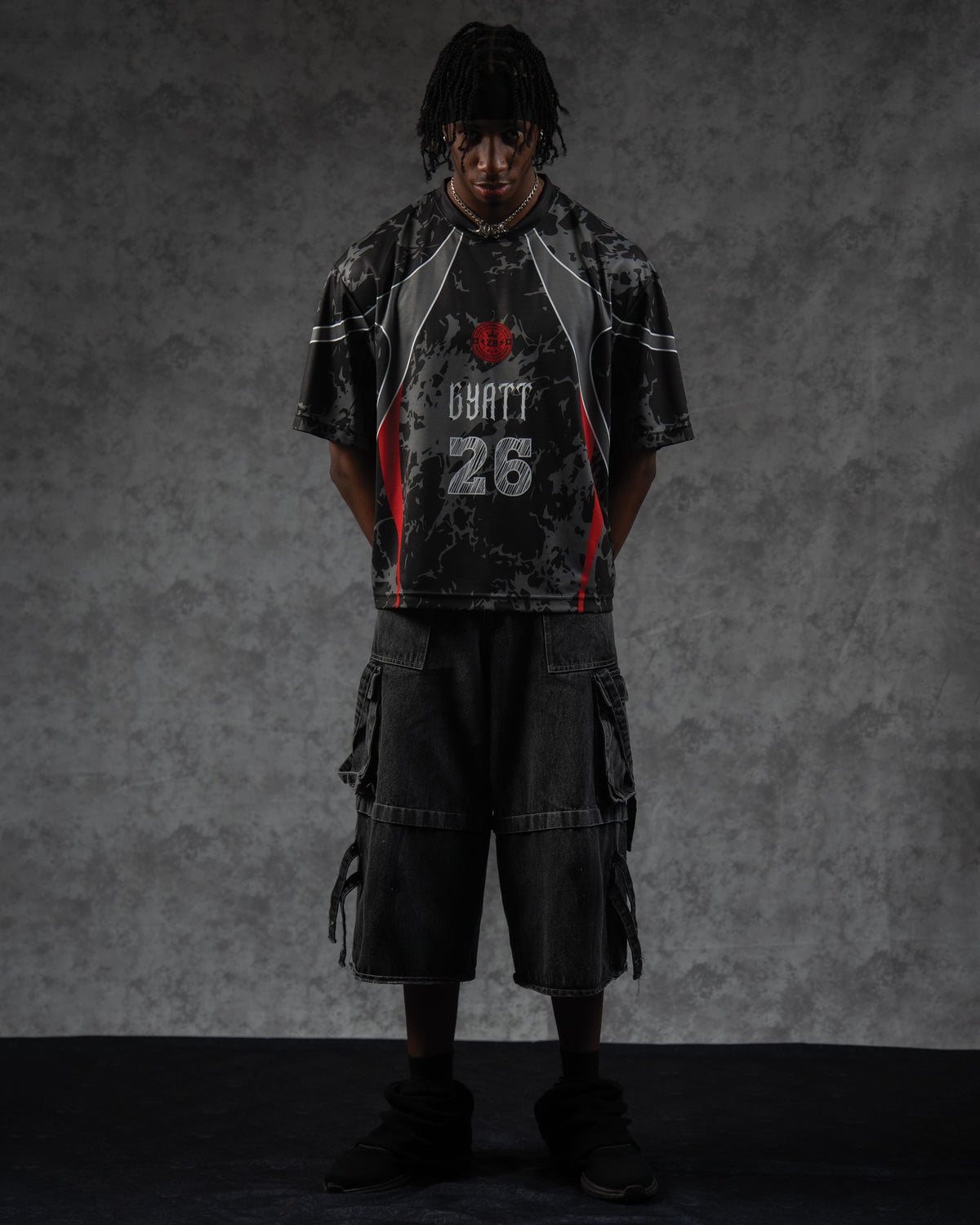 Full-length portrait of a man wearing the ZBRIX_26 jersey styled with baggy black denim