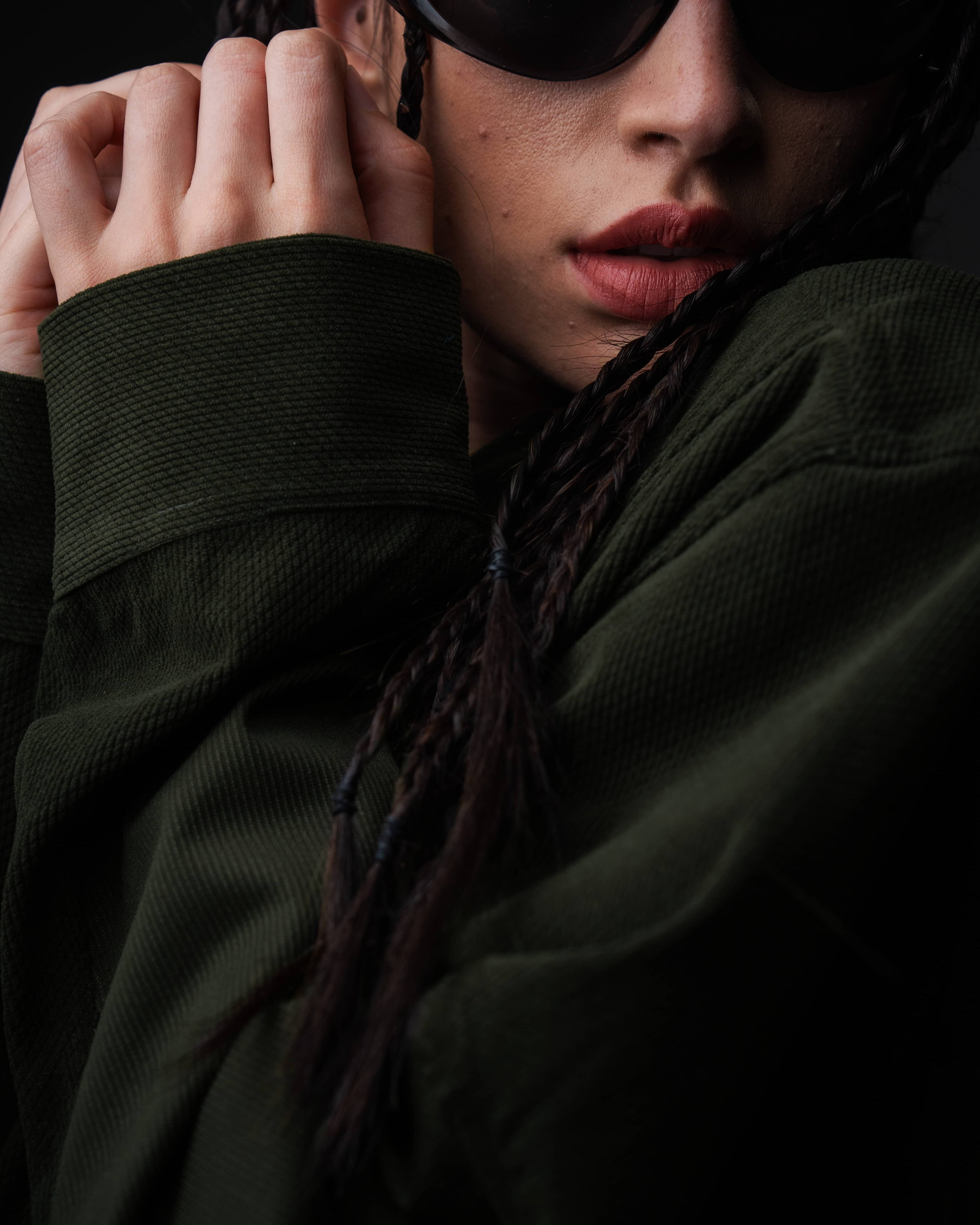 Extreme close-up macro shot of the textured fabric and buttoned cuff on a dark olive shirt