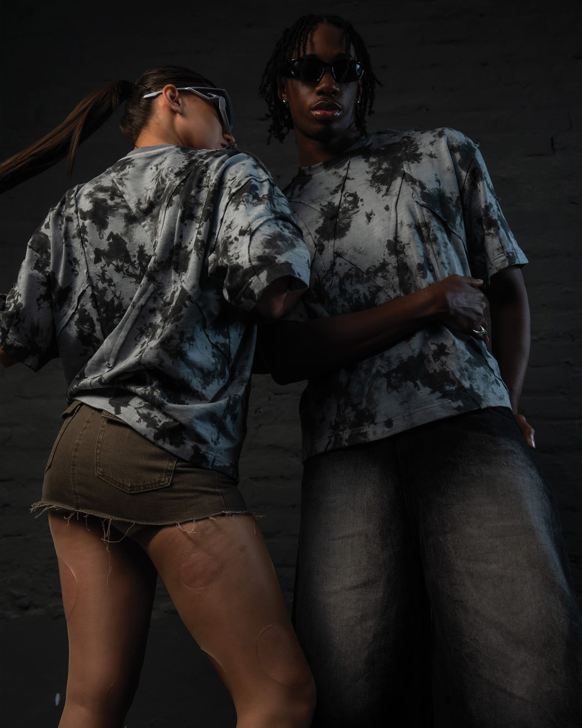 Low-angle editorial shot of SCAR_ASH oversized acid wash luxury streetwear t-shirt