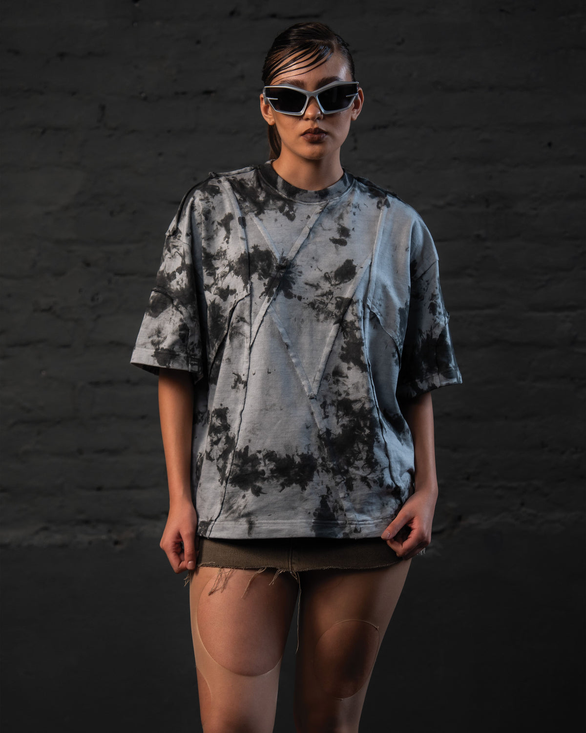 Female model styling oversized streetwear t-shirt in a futuristic urban look, full front view