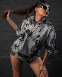 Female model in a dynamic fashion pose wearing oversized acid wash streetwear t-shirt