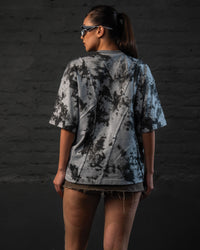 Back view of female model wearing premium oversized streetwear t-shirt with abstract wash pattern