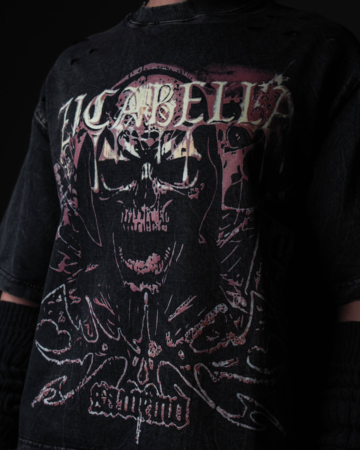 Close-up macro view of the premium skull graphic artwork on a washed black oversized t-shirt
