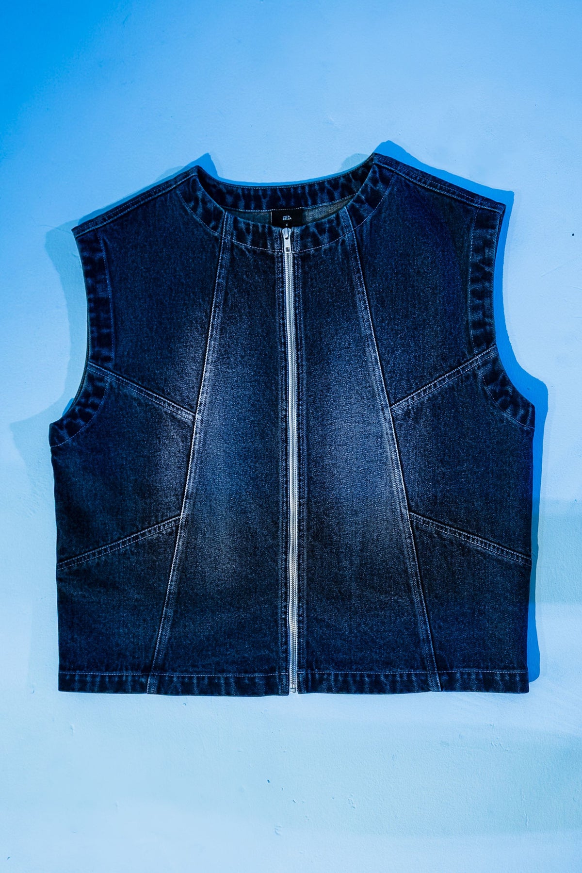 Close-up view of sleeveless denim jacket for men highlighting fabric wash and stitching