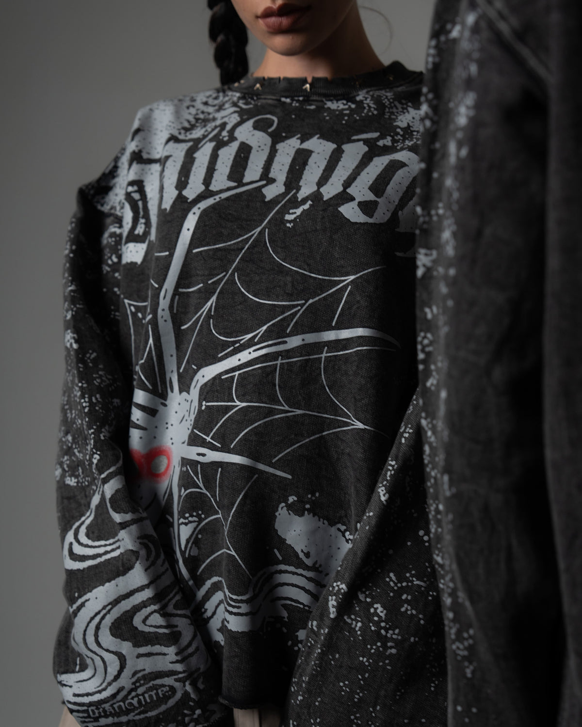 Macro detail shot of the high-quality spiderweb screenprint on a washed charcoal oversized long sleeve tee