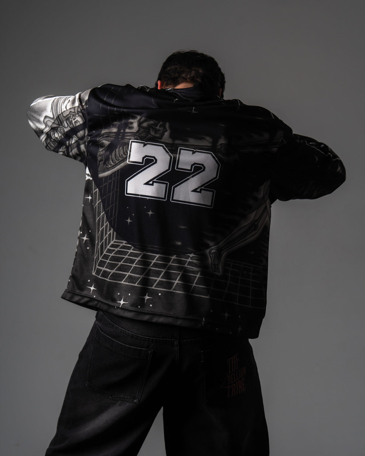 Back view of a male model showing the large silver number 22 print on the black oversized TRPPY_22 jersey