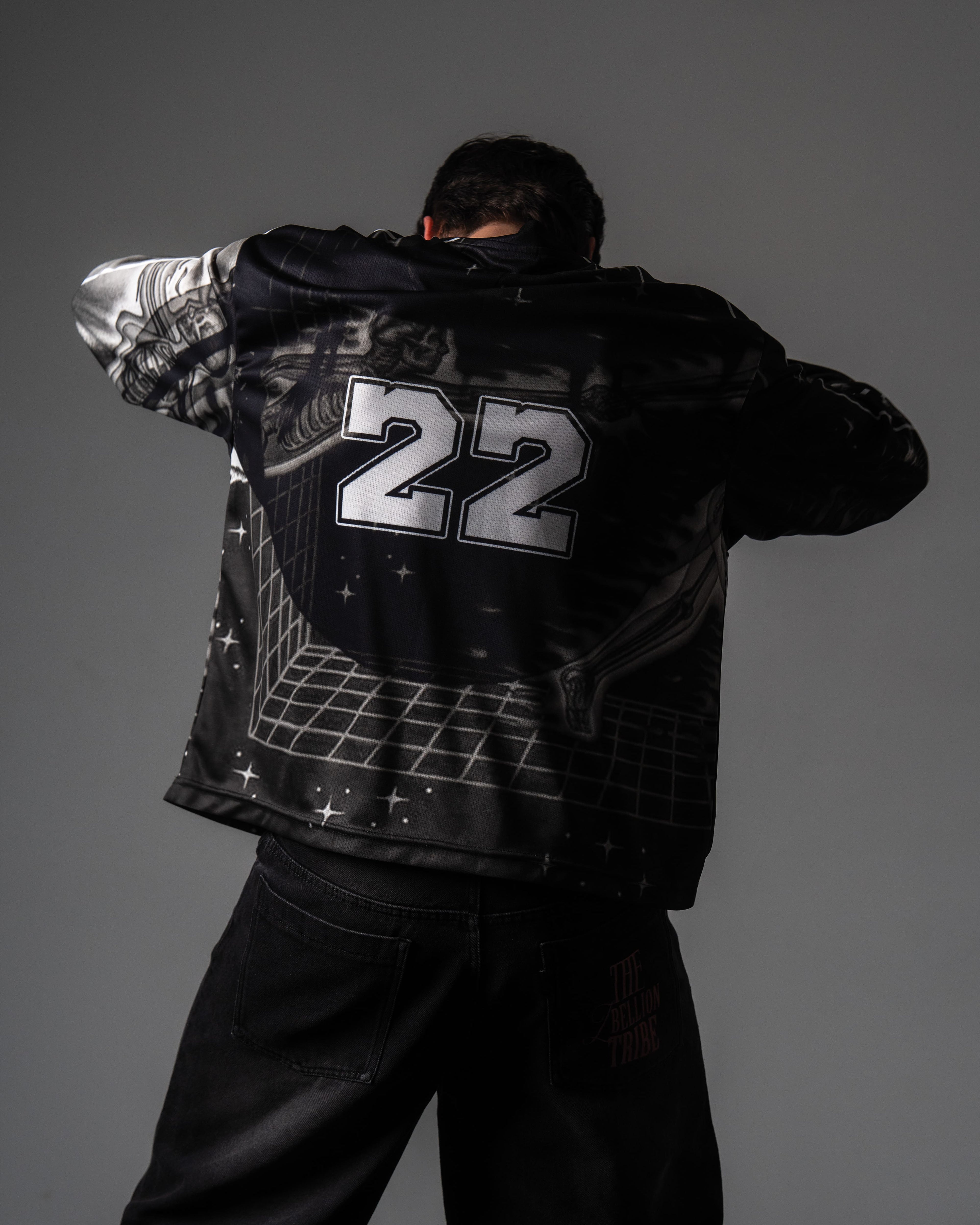 Back view of a male model showing the large silver number 22 print on the black oversized TRPPY_22 jersey
