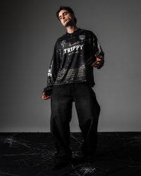 Full body studio portrait of a model wearing the TRPPY_22 oversized long sleeve jersey with black denim