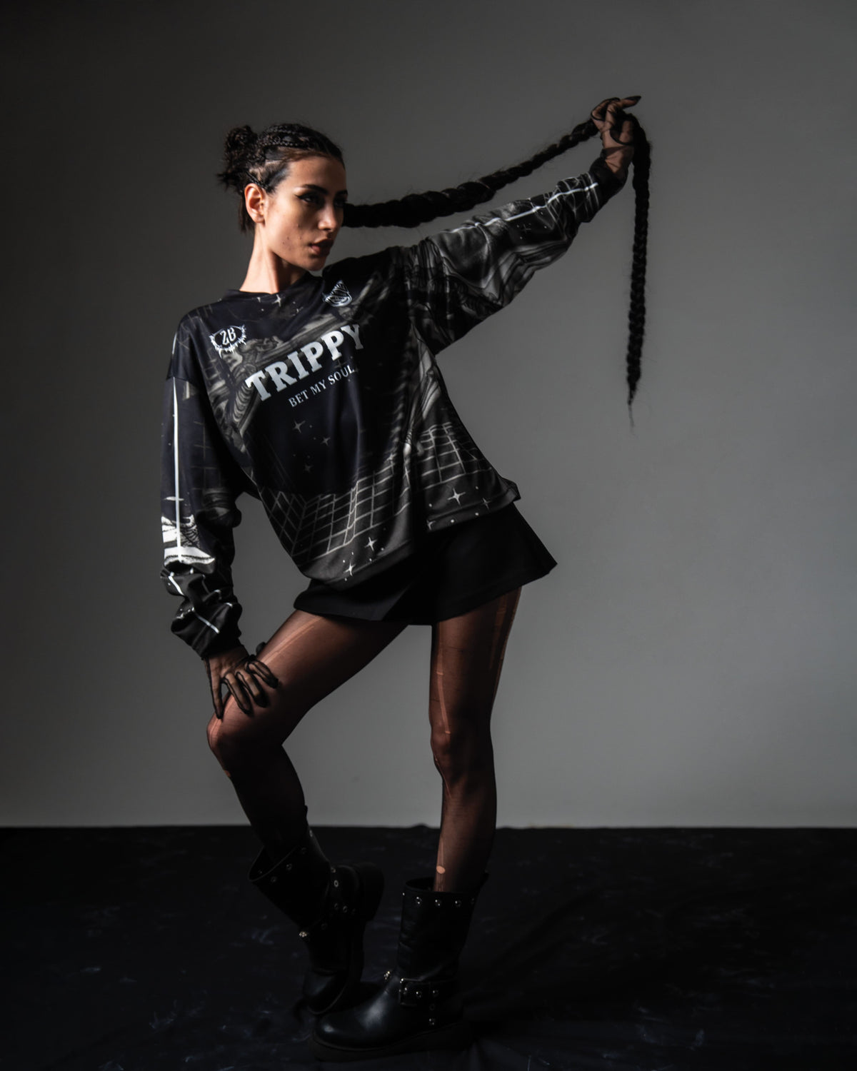 Female model styling the oversized TRPPY_22 jersey with chunky black combat boots in a streetwear outfit.