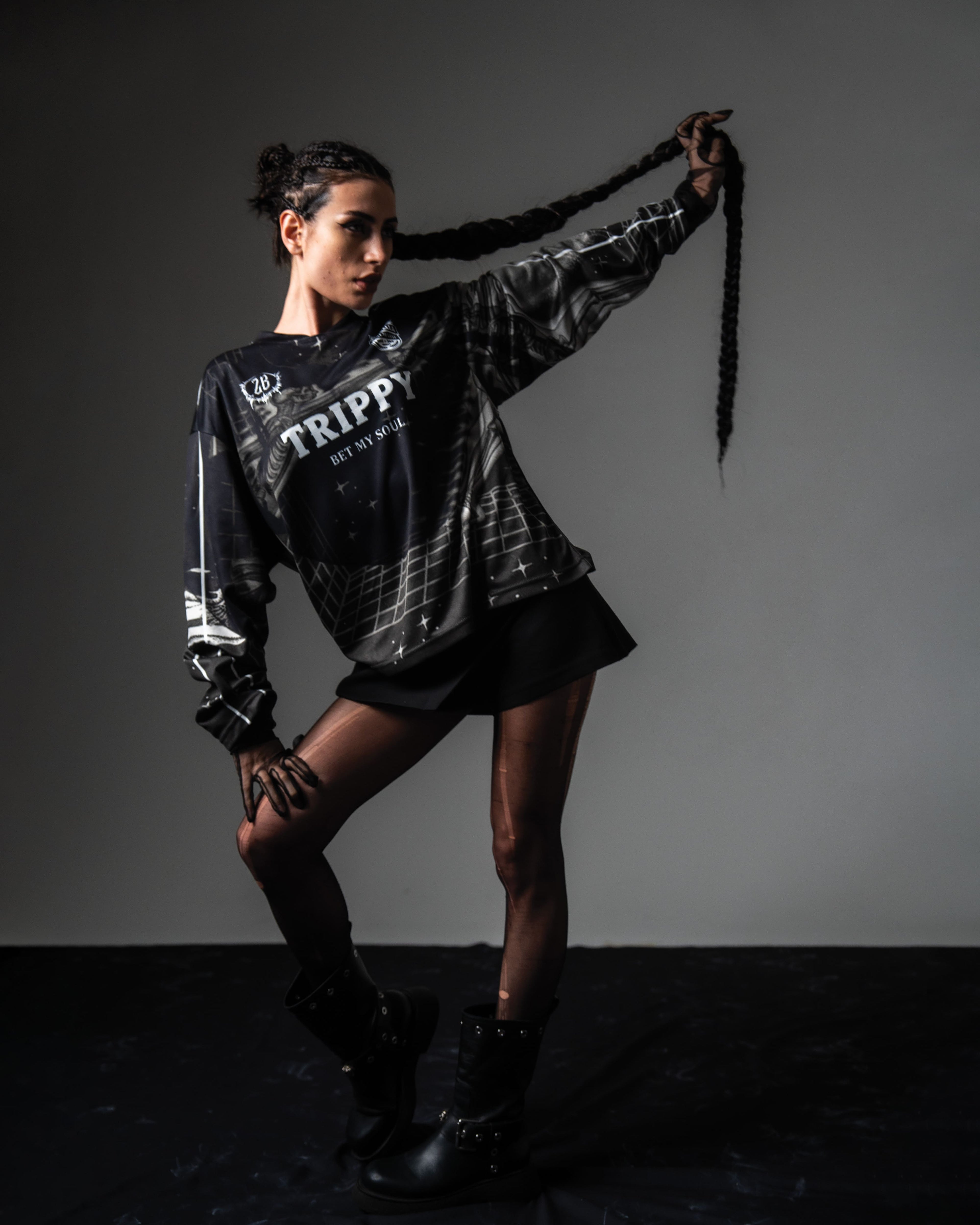 Female model styling the oversized TRPPY_22 jersey with chunky black combat boots in a streetwear outfit.