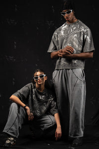 Relaxed-fit editorial studio shot of oversized charcoal graphic t-shirts on models